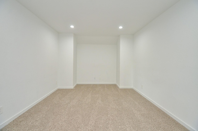 empty room with light carpet, baseboards, and recessed lighting