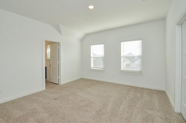 unfurnished room featuring vaulted ceiling, recessed lighting, baseboards, and light colored carpet