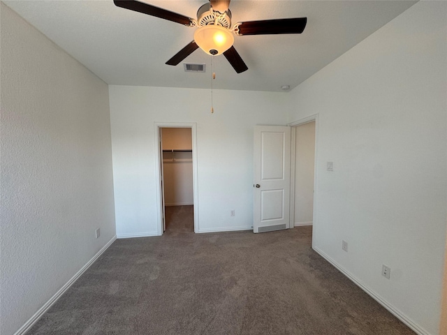 unfurnished bedroom featuring a spacious closet, carpet floors, visible vents, and baseboards