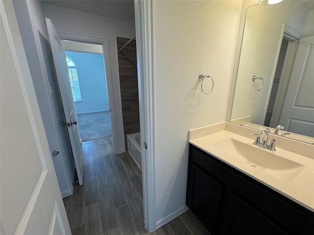 full bathroom with shower / bath combination, a textured wall, wood tiled floor, and vanity