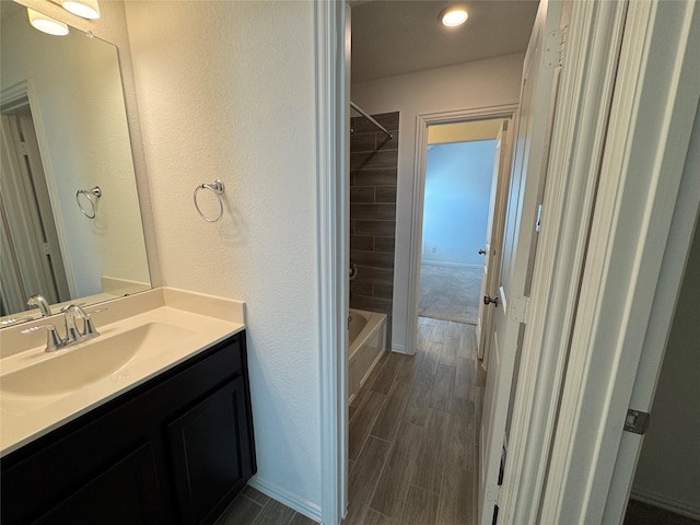 full bath featuring washtub / shower combination, wood finish floors, and vanity