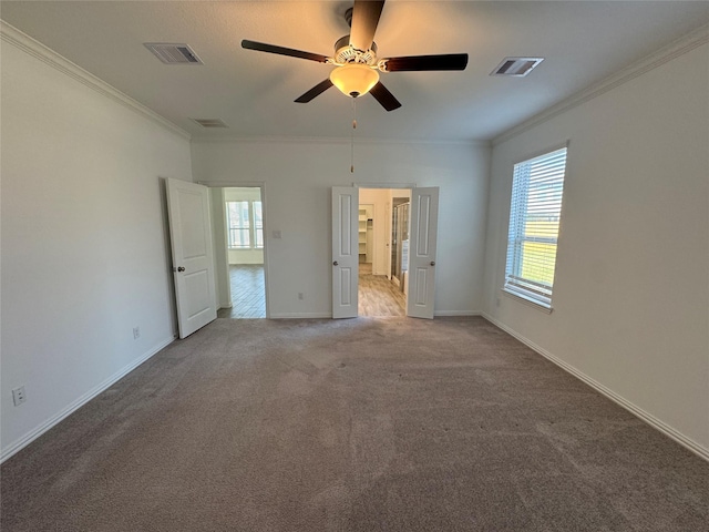 unfurnished bedroom with carpet floors, ornamental molding, and visible vents