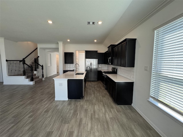 kitchen with visible vents, light countertops, appliances with stainless steel finishes, dark cabinetry, and backsplash