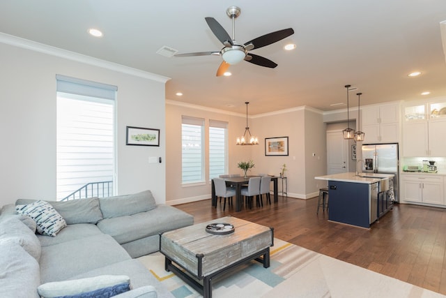 living room featuring ornamental molding, dark wood finished floors, visible vents, and recessed lighting