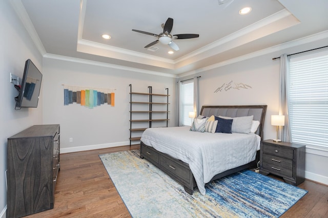 bedroom featuring ornamental molding, dark wood-type flooring, and a raised ceiling