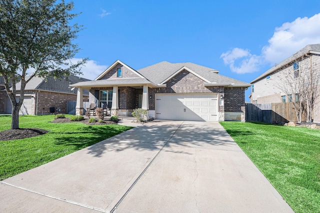 view of front of property with covered porch, a front yard, fence, and a garage