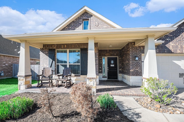 entrance to property featuring covered porch, brick siding, and an attached garage