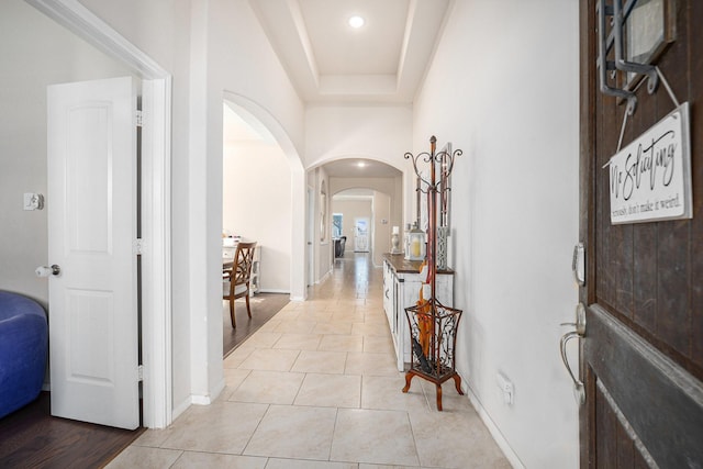 entryway featuring arched walkways, recessed lighting, baseboards, and light tile patterned floors