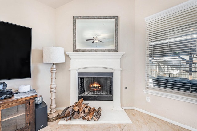 details featuring a warm lit fireplace and baseboards