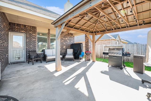 view of patio / terrace featuring area for grilling, fence, an outdoor living space, and a gazebo