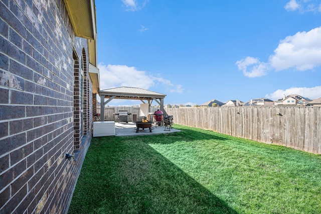 view of yard with a gazebo, an outdoor fire pit, a patio area, and a fenced backyard