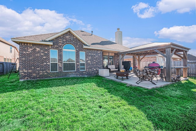 back of house with brick siding, a lawn, a gazebo, an outdoor fire pit, and a patio area