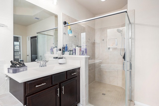 bathroom featuring vanity, visible vents, and a shower stall