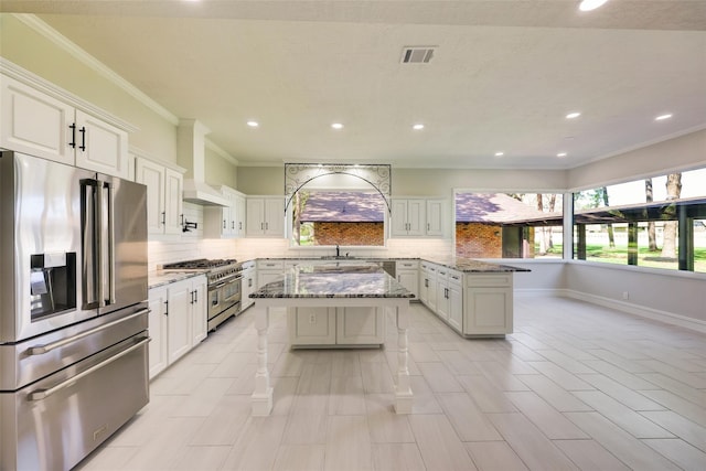 kitchen featuring stainless steel appliances, a peninsula, custom exhaust hood, visible vents, and backsplash