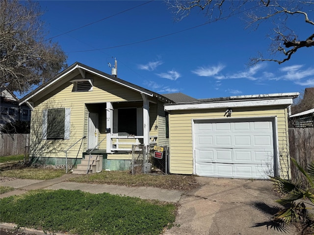 view of front of property featuring a garage, driveway, covered porch, and fence