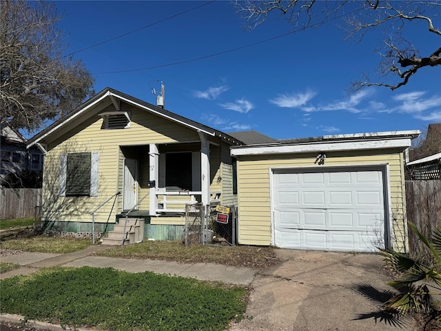 view of front of property featuring a garage, driveway, covered porch, and fence