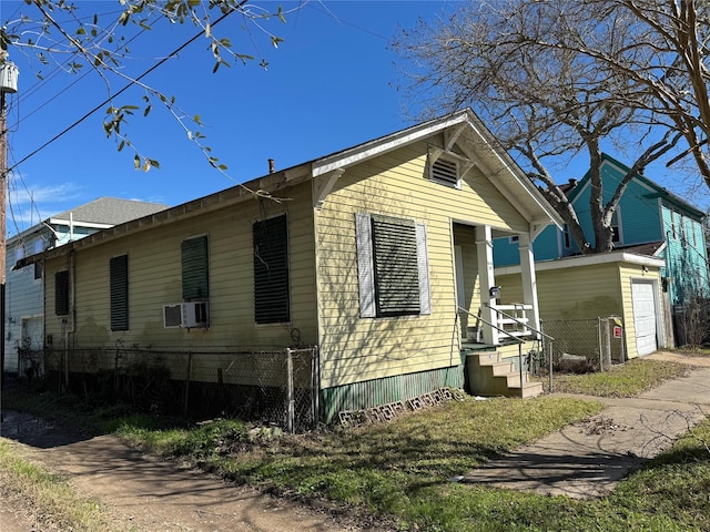 view of side of home with a garage and fence