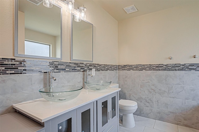 full bath featuring double vanity, tile patterned flooring, a sink, and visible vents