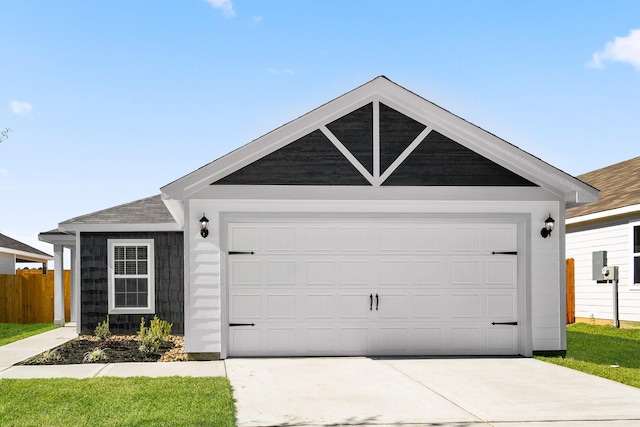 ranch-style home featuring a garage, a front yard, driveway, and fence