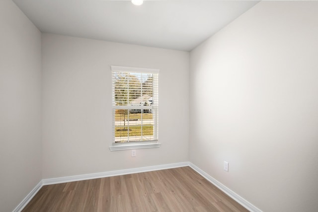 spare room featuring light wood finished floors and baseboards