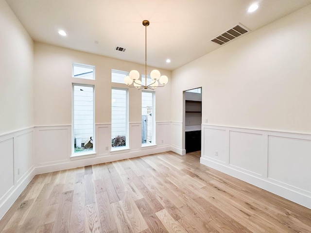 spare room featuring a chandelier, recessed lighting, a wainscoted wall, visible vents, and light wood finished floors