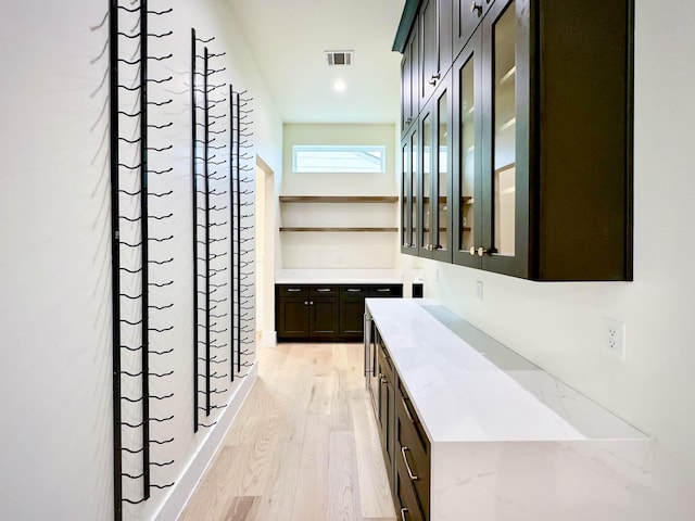 bar featuring light wood-style floors and visible vents