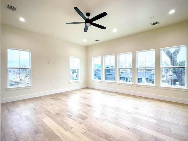 empty room with light wood-type flooring, visible vents, baseboards, and recessed lighting