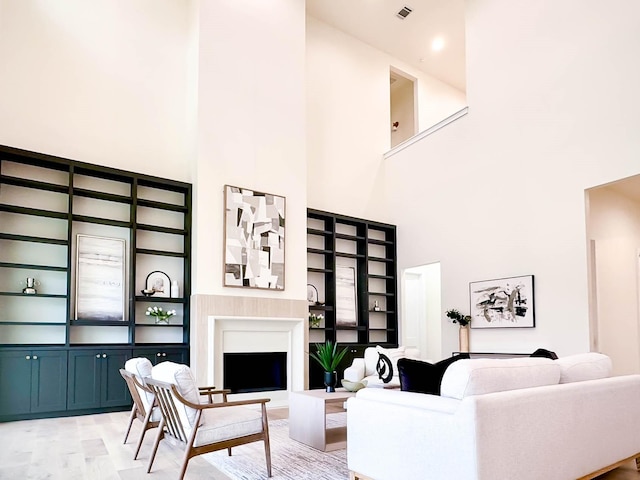 living room with light wood-style floors, a fireplace, and built in features