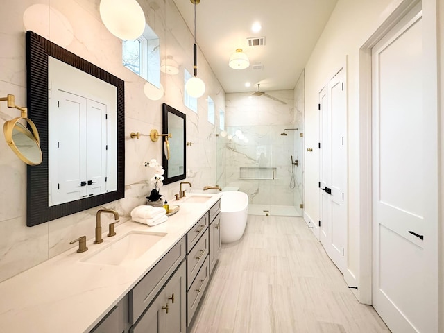 full bath featuring double vanity, a marble finish shower, visible vents, and a sink