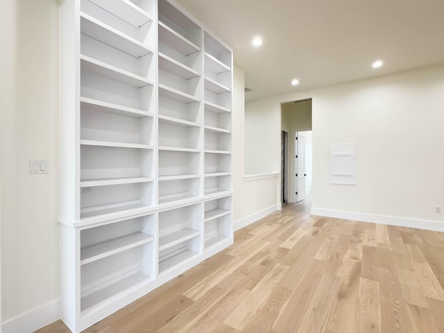 empty room with baseboards, light wood-type flooring, and recessed lighting