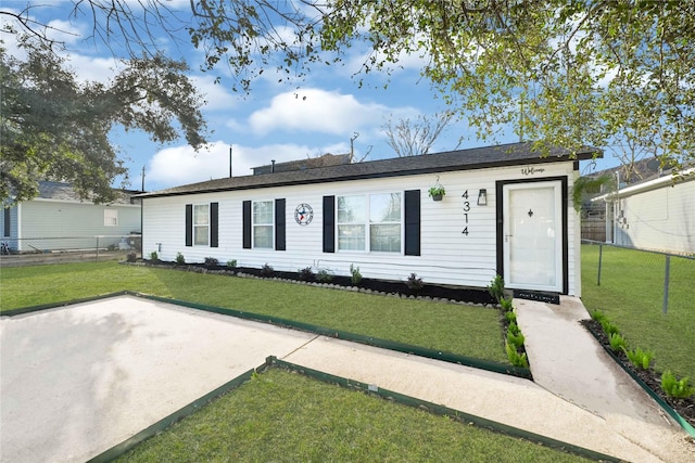 ranch-style home featuring fence and a front yard