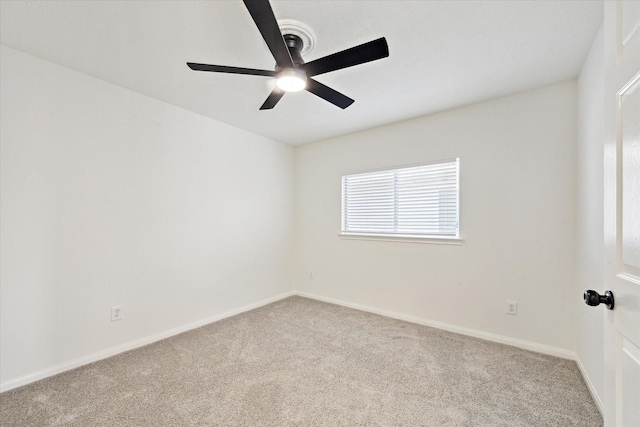 empty room with light carpet, a ceiling fan, and baseboards