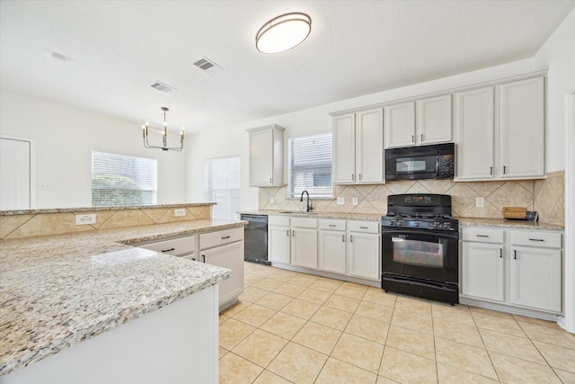 kitchen with white cabinets, visible vents, decorative light fixtures, and black appliances