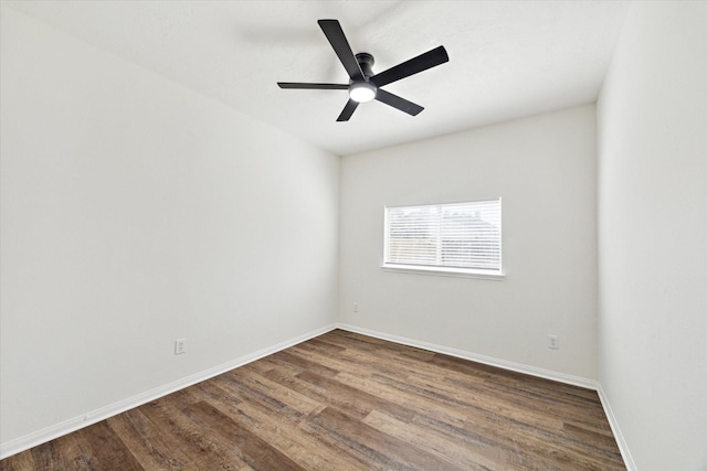 spare room featuring ceiling fan, dark wood finished floors, and baseboards