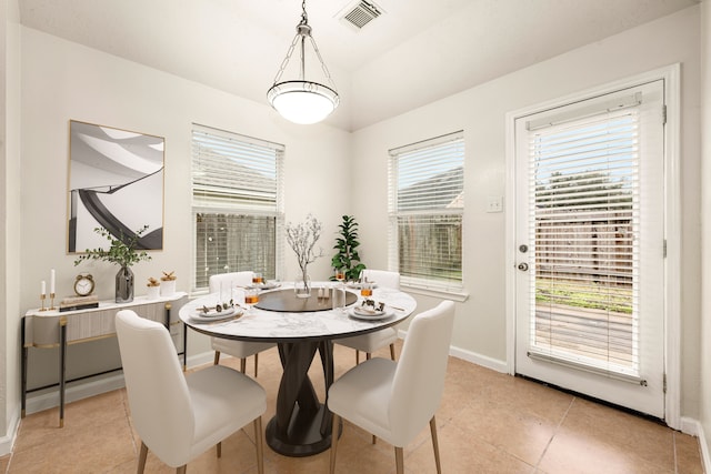 dining room featuring light tile patterned flooring, visible vents, and baseboards