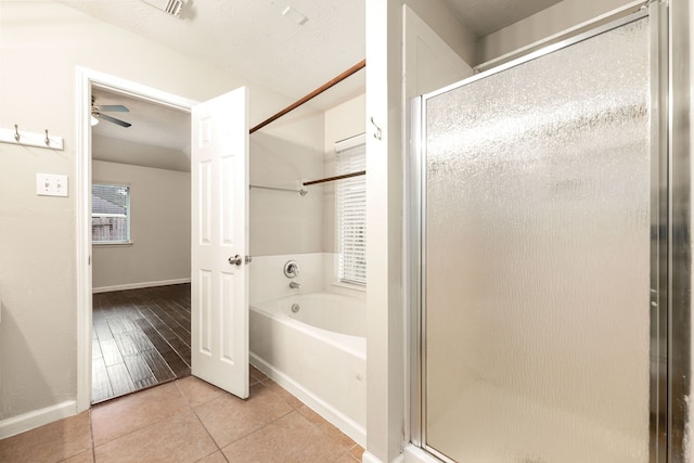 full bathroom with a stall shower, tile patterned flooring, a garden tub, and baseboards