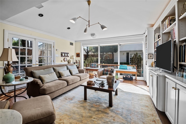 living room featuring light wood-style floors, visible vents, ornamental molding, and french doors