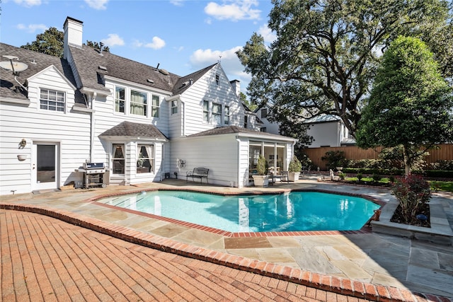 view of swimming pool featuring a fenced in pool, a patio area, and fence