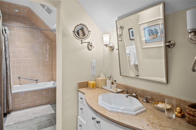 bathroom featuring lofted ceiling, tiled shower / bath combo, vanity, and tile patterned floors