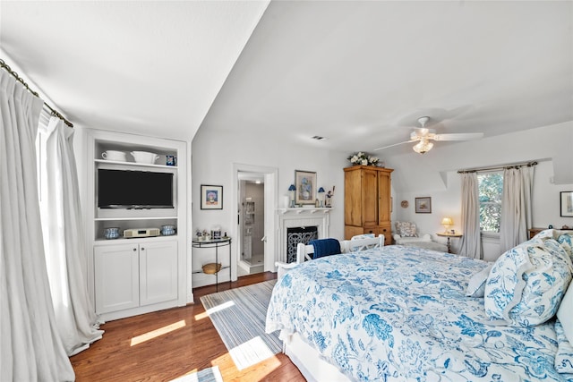 bedroom with a fireplace, wood finished floors, and visible vents