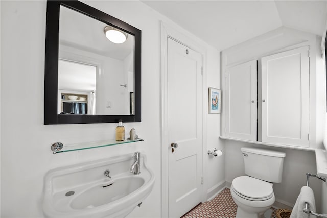 half bathroom with baseboards and toilet