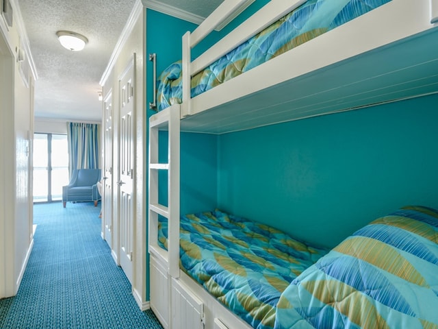 bedroom with a textured ceiling, carpet floors, and crown molding