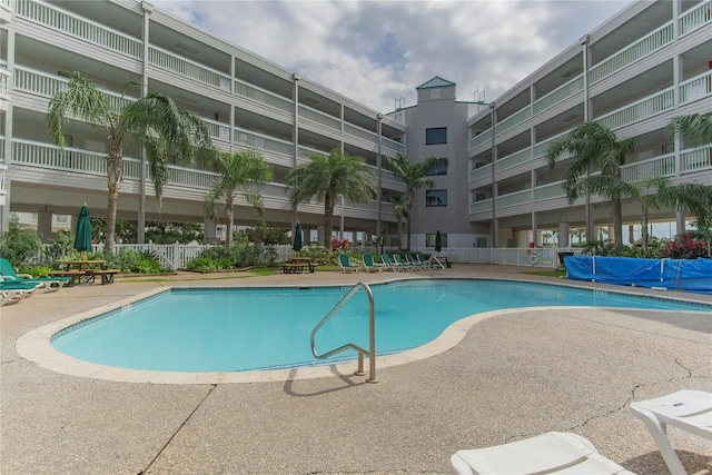 community pool featuring fence and a patio