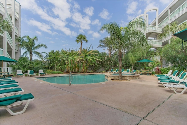 view of swimming pool featuring a patio and a pool with connected hot tub