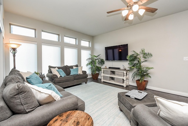 living area with a ceiling fan, baseboards, and wood finished floors