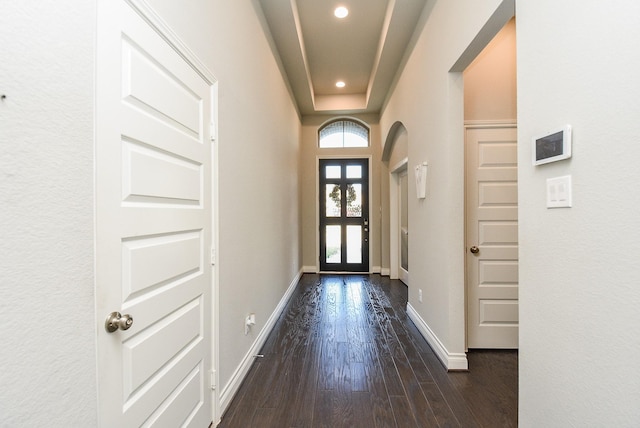 entryway featuring arched walkways, recessed lighting, dark wood finished floors, and baseboards