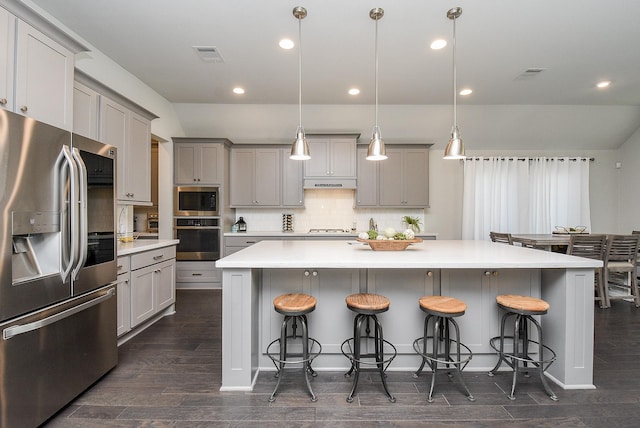 kitchen with under cabinet range hood, visible vents, appliances with stainless steel finishes, and gray cabinetry