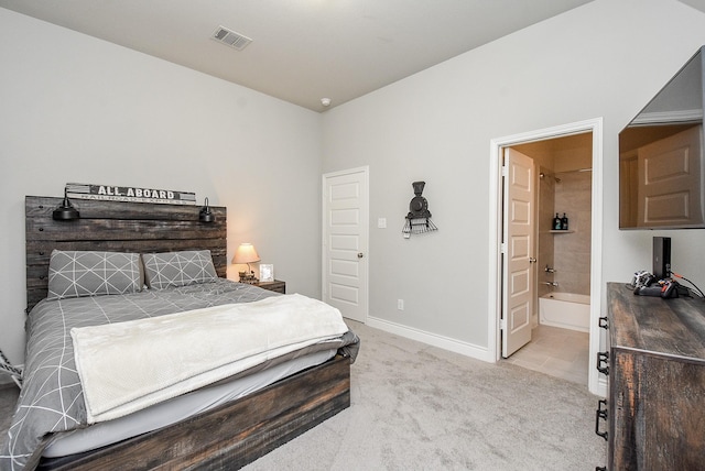 bedroom featuring light carpet, ensuite bath, visible vents, and baseboards