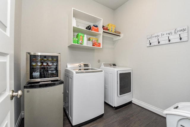 laundry area with dark wood-type flooring, washing machine and dryer, laundry area, and baseboards