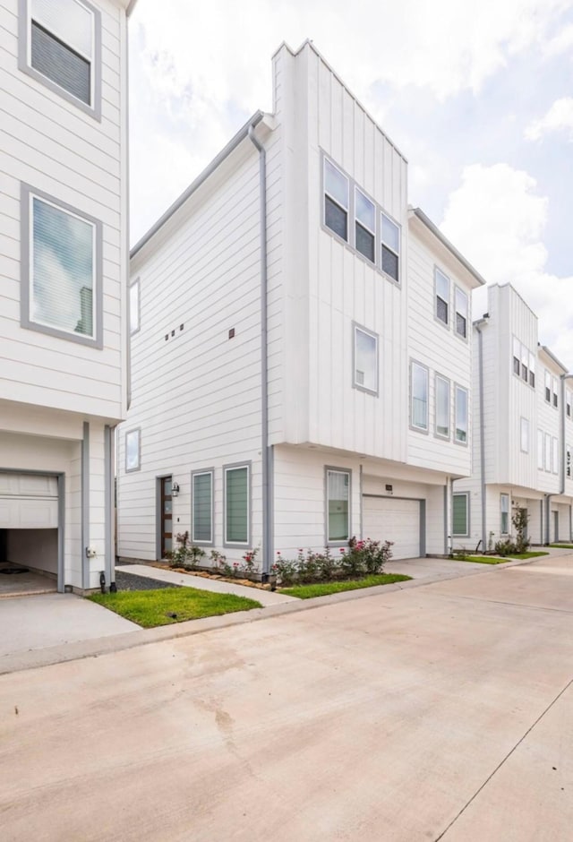 view of front facade featuring board and batten siding, concrete driveway, and an attached garage